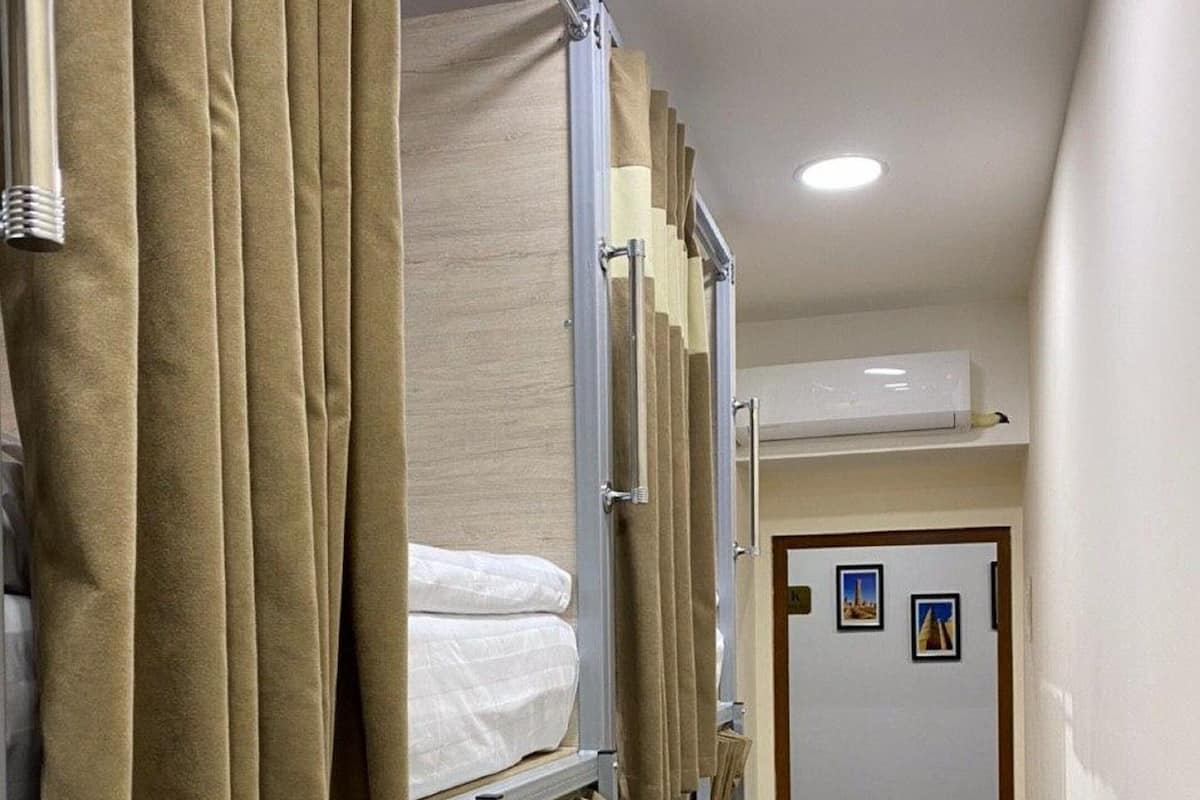 Ett rum med en våningssäng, draperier och en dörr med bilder på.