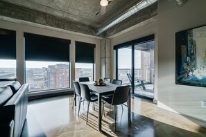 Een moderne kantoorruimte met een grote tafel, stoelen en een stadszicht door grote ramen.