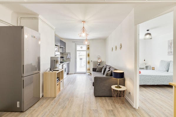 A modern apartment with a kitchen, living area, and bedroom.