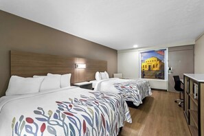 A hotel room with two beds, a desk, a chair, and a large window with a view of a building. - Red Roof Inn Radcliff - Fort Knox (Radcliff)