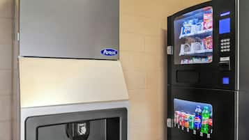 A vending machine with a selection of beverages and snacks, a push button, and a digital display.