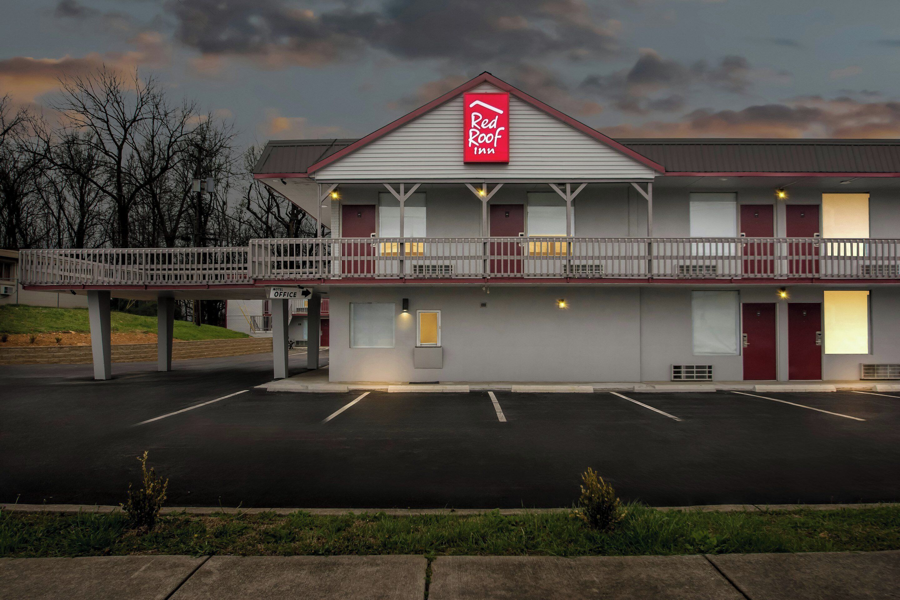 Un Red Roof Inn de dos pisos, con un corredor cubierto y un estacionamiento.
