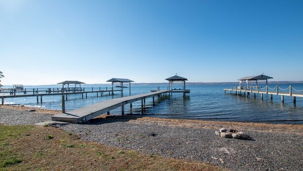 Un muelle con varios pabellones y una costa rocosa.