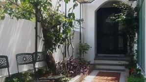 A covered patio area with tiled flooring, potted plants, and outdoor furniture. - Ristorante B&B Posidonia (Sapri)