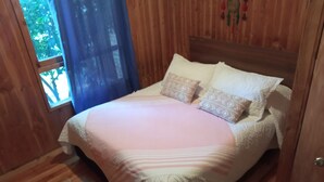 A wooden room with a bed, a window, and a door. - House with terrace near the lake, national parks and caburgua eyes (Pucon)