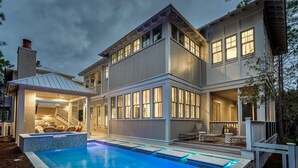 Et toetagers hus med swimmingpool, store vinduer og en overdækket terrasse.