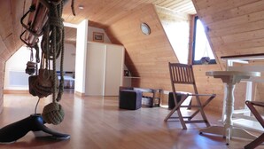 Un loft espacioso con suelos de madera, una mesa de comedor, una silla y una cuerda colgante.