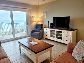 A living room with a sofa, a coffee table, a TV, a cabinet, and a chair.