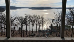 A view from a covered area overlooking a lake with trees and rocks.