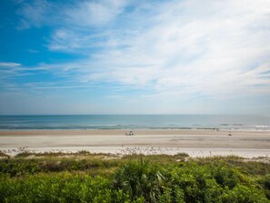 Une plage avec un ciel dégagé et une mer calme.
