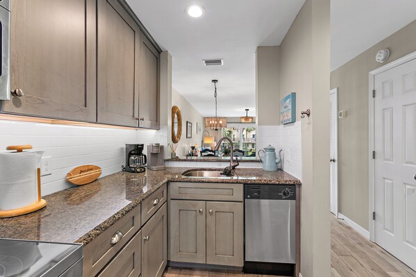 A modern kitchen with granite countertops, stainless steel appliances, and wooden cabinets.
