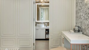 A modern bathroom with a large mirror, white cabinetry, and a vanity with a sink. - Miraval Luxury Rooms (Split)