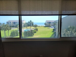 Guests can enjoy a serene view of the surrounding residential area, pool, and ocean from the comfort of their room.