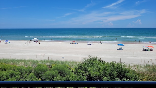 A beach with a clear sky, calm sea, and sparse beachgoers. - Oceanfront 2 Bedroom Townhouse Summerhouse 209 (ST. AUGUSTINE)