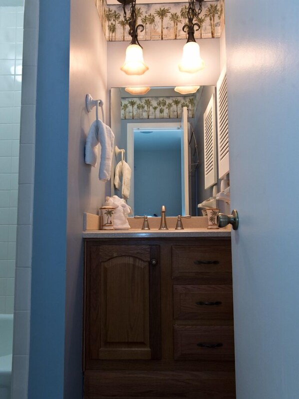 A bathroom with a wooden vanity, two pendant lights, a mirror, and a towel rack. - Summerhouse 224 Townhouse with view from balcony (ST. AUGUSTINE)