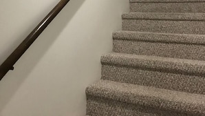 En trappe med trægelænder og tæppe beklædte trin.