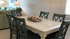 Et spiseområde med et træbord og stole, en dekorativ lampe og et billede på væggen.