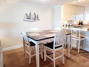 Enjoy a well-equipped kitchen and dining area with a microwave, coffee maker, and sink, perfect for preparing meals and relaxing with friends and family.