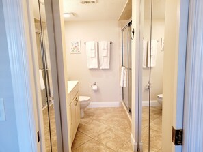 Bathroom features a glass-enclosed shower, toilet, and sink with vanity.