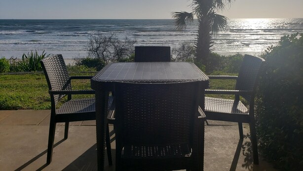 A patio with a table and chairs overlooking the ocean. - Oceanfront 2 Bedroom Flat Summerhouse 301 (ST. AUGUSTINE)