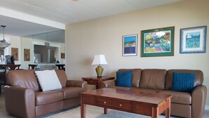 A living room with two brown leather sofas, a wooden coffee table, and a patterned rug. - Oceanfront 2 Bedroom Flat Summerhouse 301 (ST. AUGUSTINE)