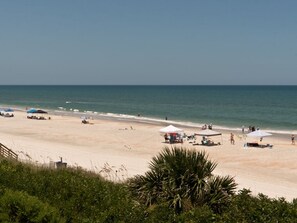 A beach with tents and umbrellas, a sandy shore, and the ocean. - Oceanfront 2 Bedroom Townhouse Summerhouse 302 (ST. AUGUSTINE)