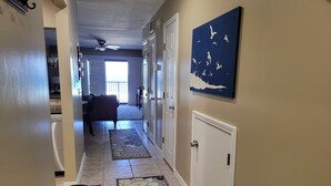 A hallway with a ceiling fan, a dining area with a table and chairs, and a living room with a sofa. - Oceanfront 2 Bedroom Townhouse Summerhouse 305 (ST. AUGUSTINE)