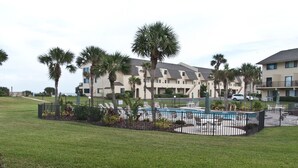 A hotel with a pool area, palm trees, and a well-maintained lawn. - Oceanview 2 Bedroom Flat Summerhouse 319 (ST. AUGUSTINE)