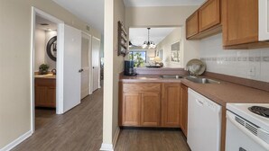 A kitchen with wooden cabinets, a dishwasher, and a stove. - Oceanview 2 Bedroom Townhouse Summerhouse 330 (ST. AUGUSTINE)