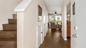 A hallway with wooden stairs leading to a balcony with a ceiling fan. - Oceanview 2 Bedroom Townhouse Summerhouse 330 (ST. AUGUSTINE)