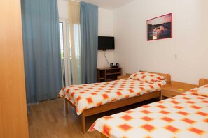 A hotel room with two beds, a TV, a desk, and a window with curtains. - Studios Nina (Split)