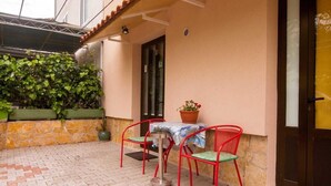 A patio with a table and chairs, a potted plant, and a door. - Studios Nina (Split)