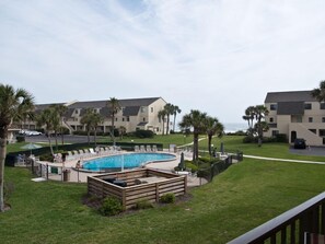 Relax by the pool surrounded by lush greenery and comfortable lounge chairs.