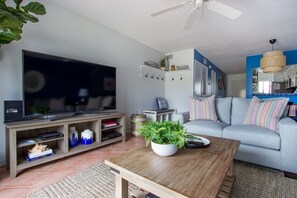 Relax in a stylish living room with a large flat-screen TV, comfortable sofa, and a wooden coffee table.