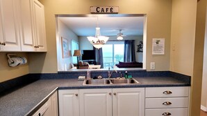 A kitchen with a built-in sink, white cabinets, and a blue countertop. - Oceanfront 2 Bedroom Townhouse.  Summerhouse Unit 353 (ST AUGUSTINE)