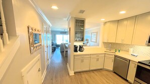 A modern kitchen with white cabinets, a stainless steel oven, and a coffee maker on the counter.