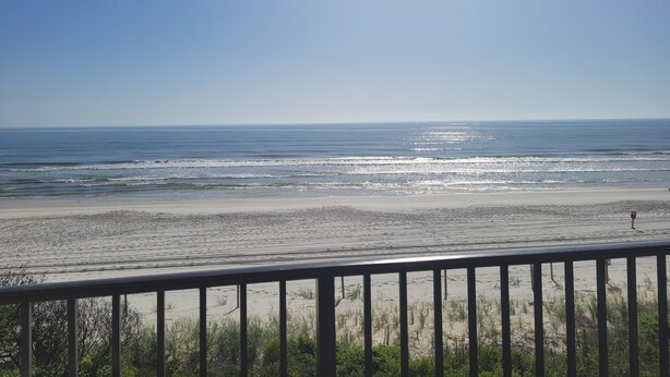 A beach view from a balcony with a railing, ocean, and clear sky. - Oceanfront 2 Bedroom Townhouse.  Summerhouse Unit 357 (ST. AUGUSTINE)