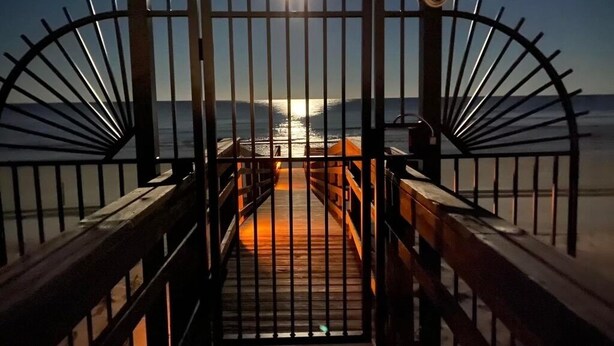 A wooden boardwalk leading to a beach with a metal gate and a moonlit sky. - Ocean view 3 bedroom 2 Bath Flat.  Summerhouse Unit 425 (ST. AUGUSTINE)