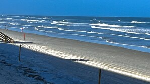 A beach with a wooden walkway and a red flag. - Ocean view 3 bedroom 2 Bath Flat.  Summerhouse Unit 425 (ST. AUGUSTINE)