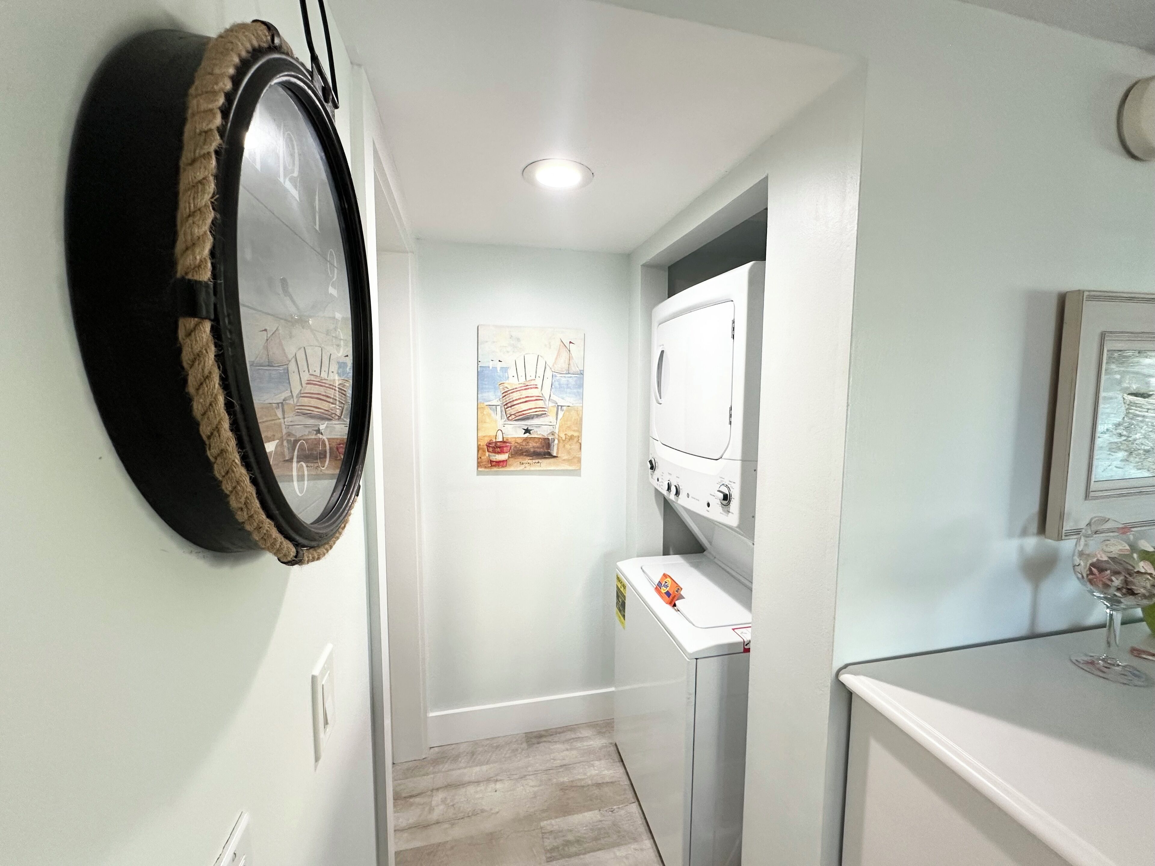 A laundry room with a washing machine, a dryer, and a wall-mounted mirror.