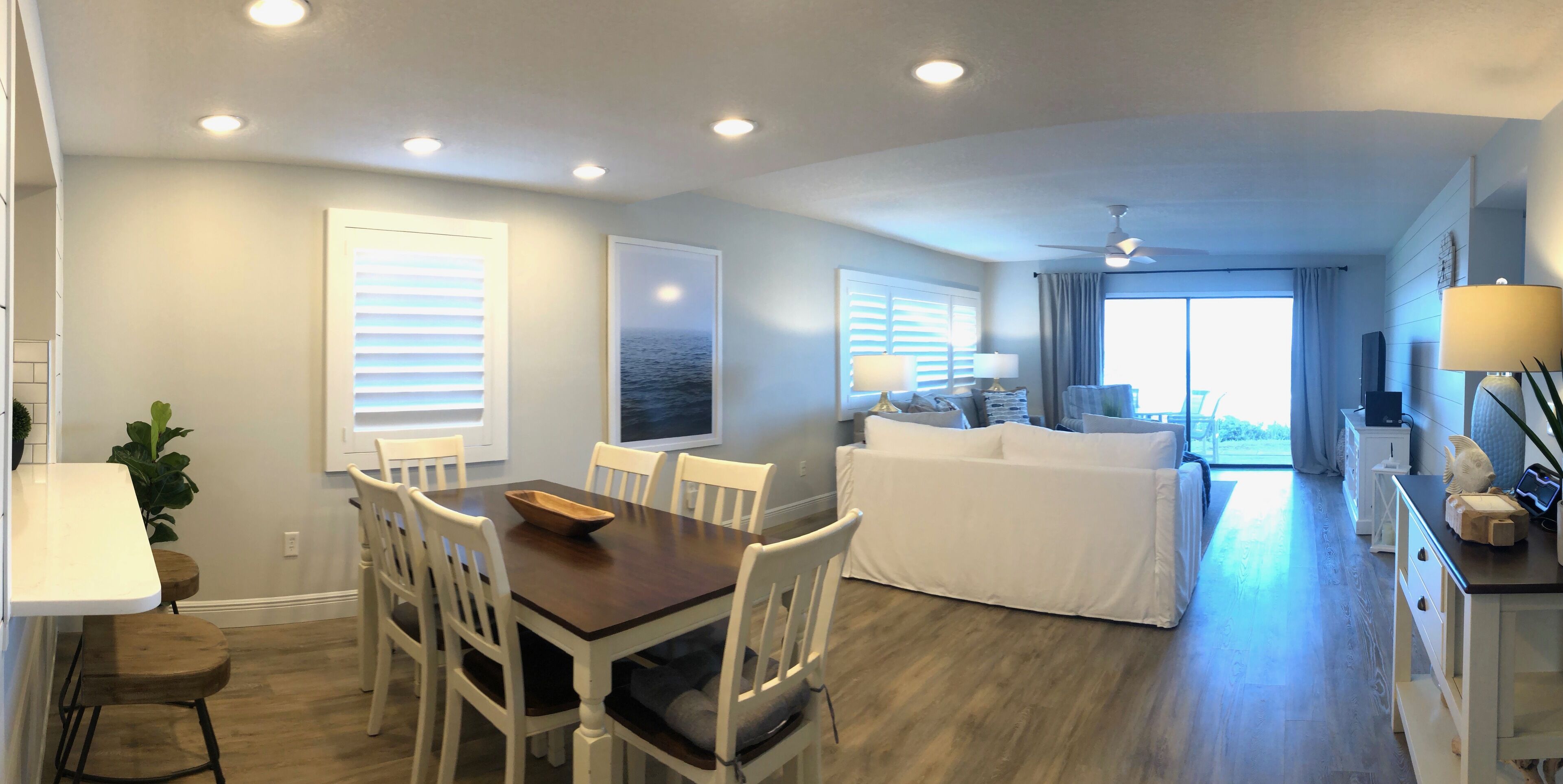 Una sala moderna con comedor, un sofá y un televisor.