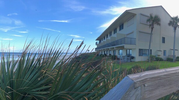 A beachfront hotel with a balcony, ocean view, and palm trees. - Oceanfront 2 Bedroom Flat  Summerhouse Unit  452 (ST. AUGUSTINE)