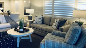 A modern living room with a sofa, armchairs, a coffee table, and a dining area. - Oceanfront 2 Bedroom Flat  Summerhouse Unit  452 (ST. AUGUSTINE)