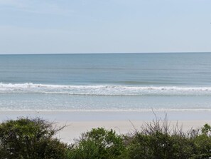 Ein Strand mit sanften Wellen und blauem Himmel.