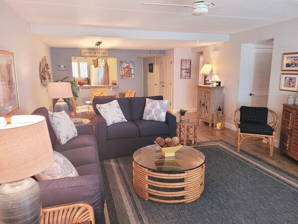 A living room with a sofa, armchairs, a coffee table, and a lamp.