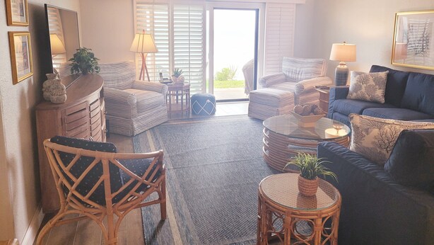 A living room with a sofa, chairs, a coffee table, and a ceiling fan.