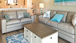 A living room with two sofas, a coffee table, and a small side table.
