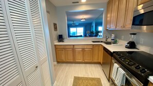 A modern kitchen with wooden cabinets, a stainless steel stove, and a built-in oven. - Don't miss this direct Oceanfront view at the beloved Summerhouse 254 (St. Augustine)