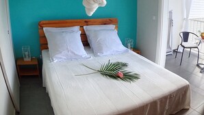 Une chambre à coucher comprenant un lit, une table de chevet, un élément décoratif mural et une fenêtre avec des rideaux.