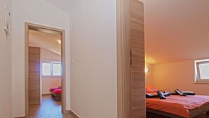 A hotel room with a bed, a desk, and a window.